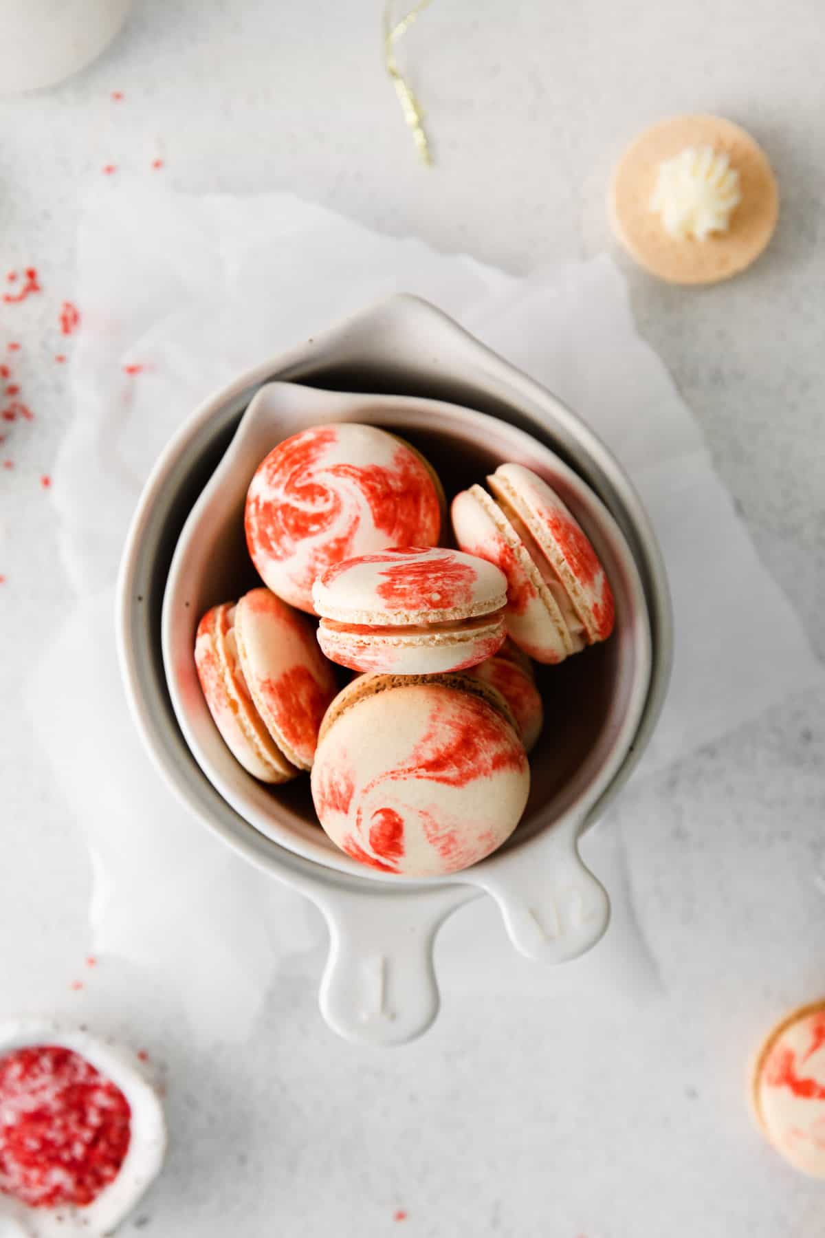 Homemade peppermint macarons with swirls of red and white on the shells.