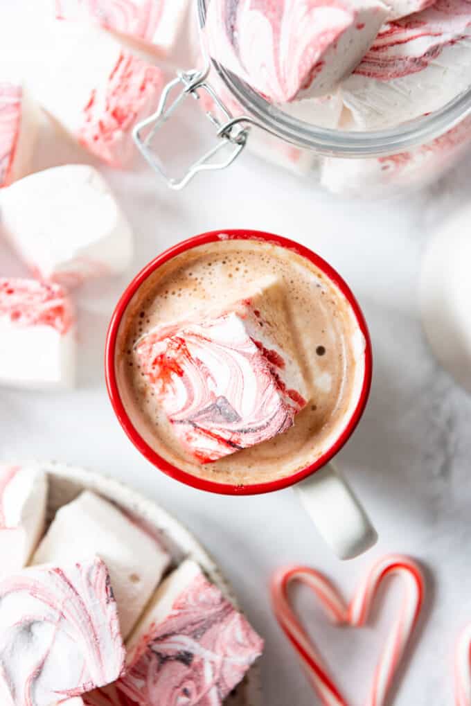 A peppermint marshmallow floating in a mug of hot cocoa.
