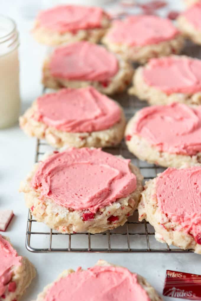 Frosted peppermint swig sugar cookies on a wire rack.