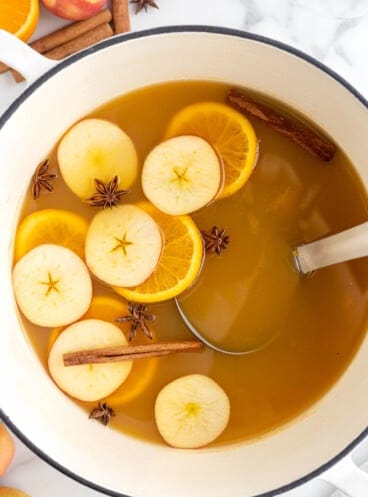 An overhead image of a large pot filled with homemade wassail.