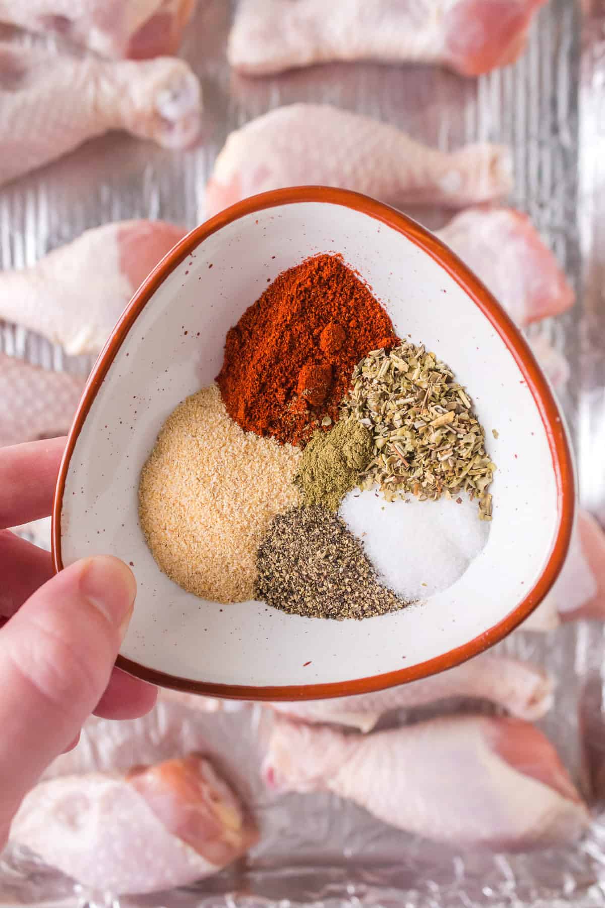 A bowl with spices and herbs to create a chicken rub.