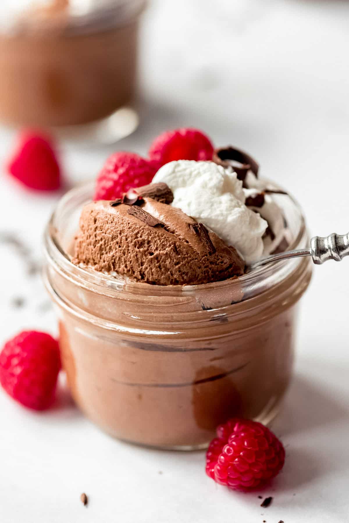 A spoon digging into Chocolate Mousse cup.