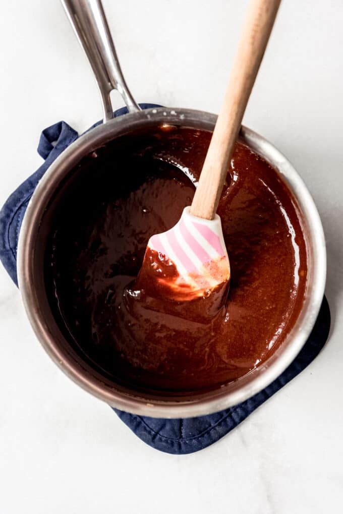 Stirring chocolate in a saucepan until it is melted.