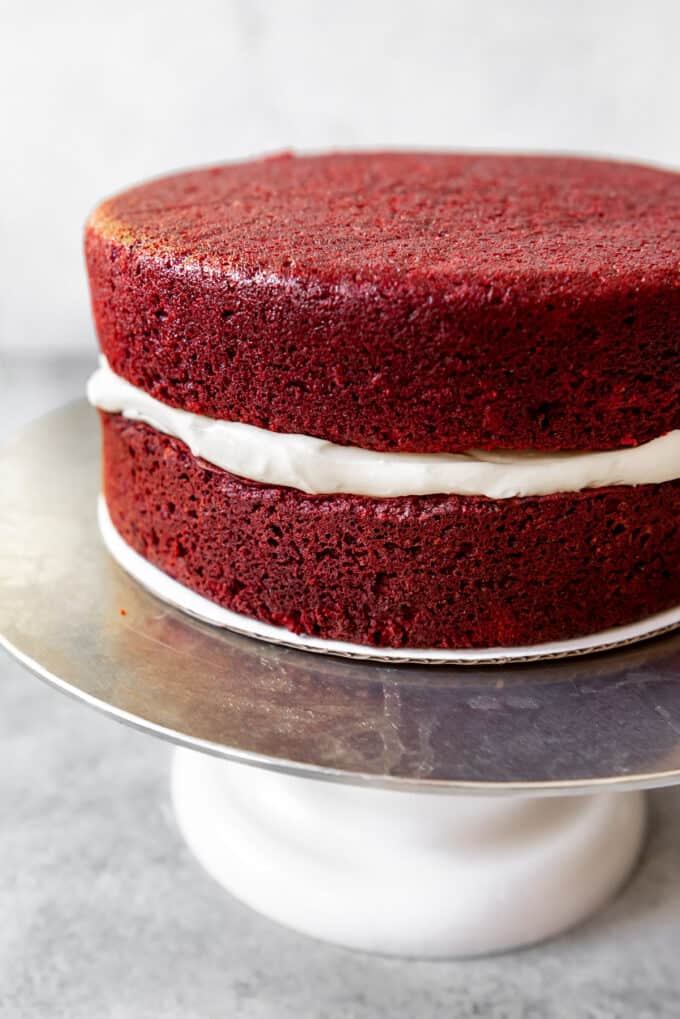 Two layers of homemade red velvet cake with cream cheese frosting in the middle and no frosting on the outside yet.