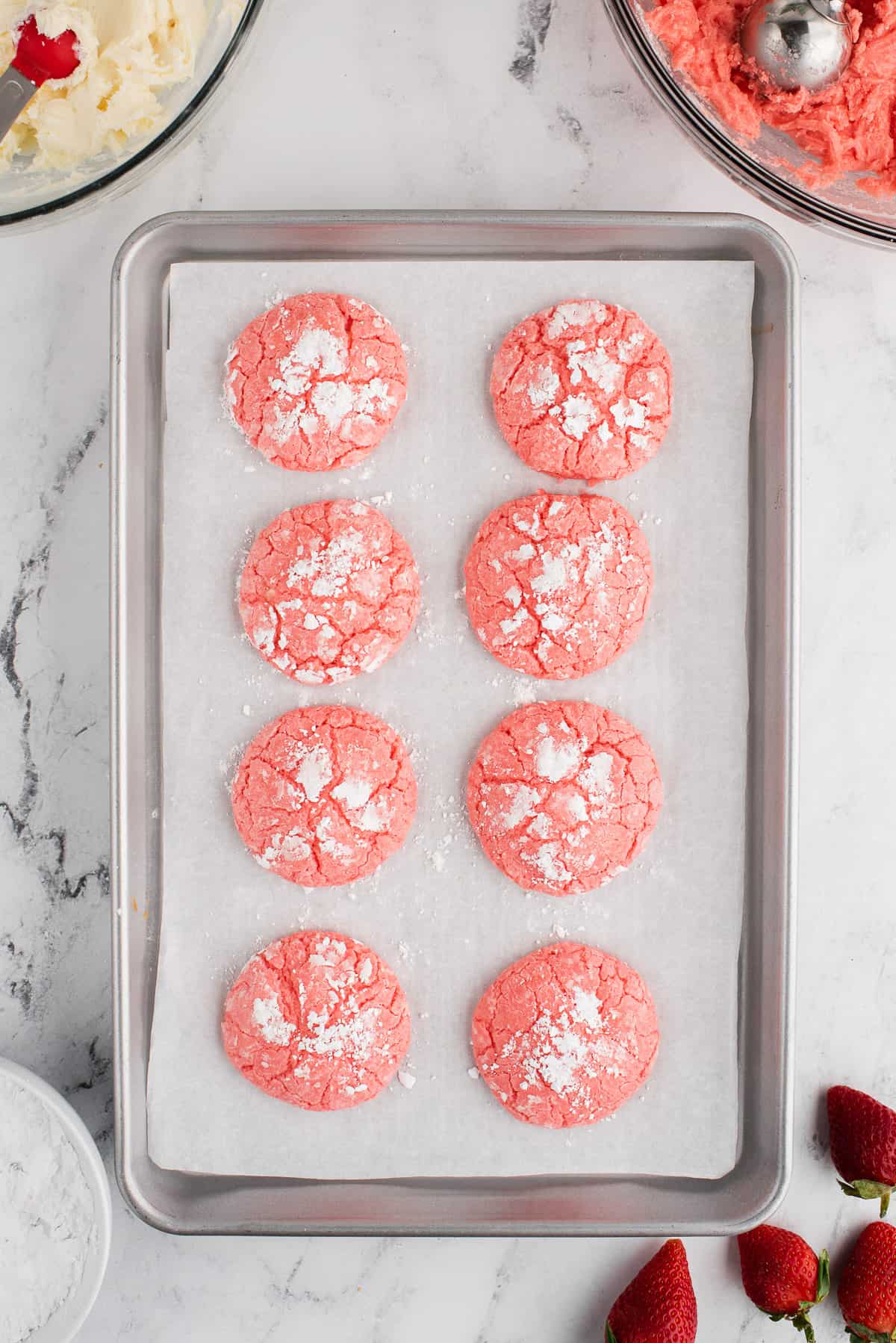 Strawberry cake mix cookies on a baking sheet lined with parchment paper.