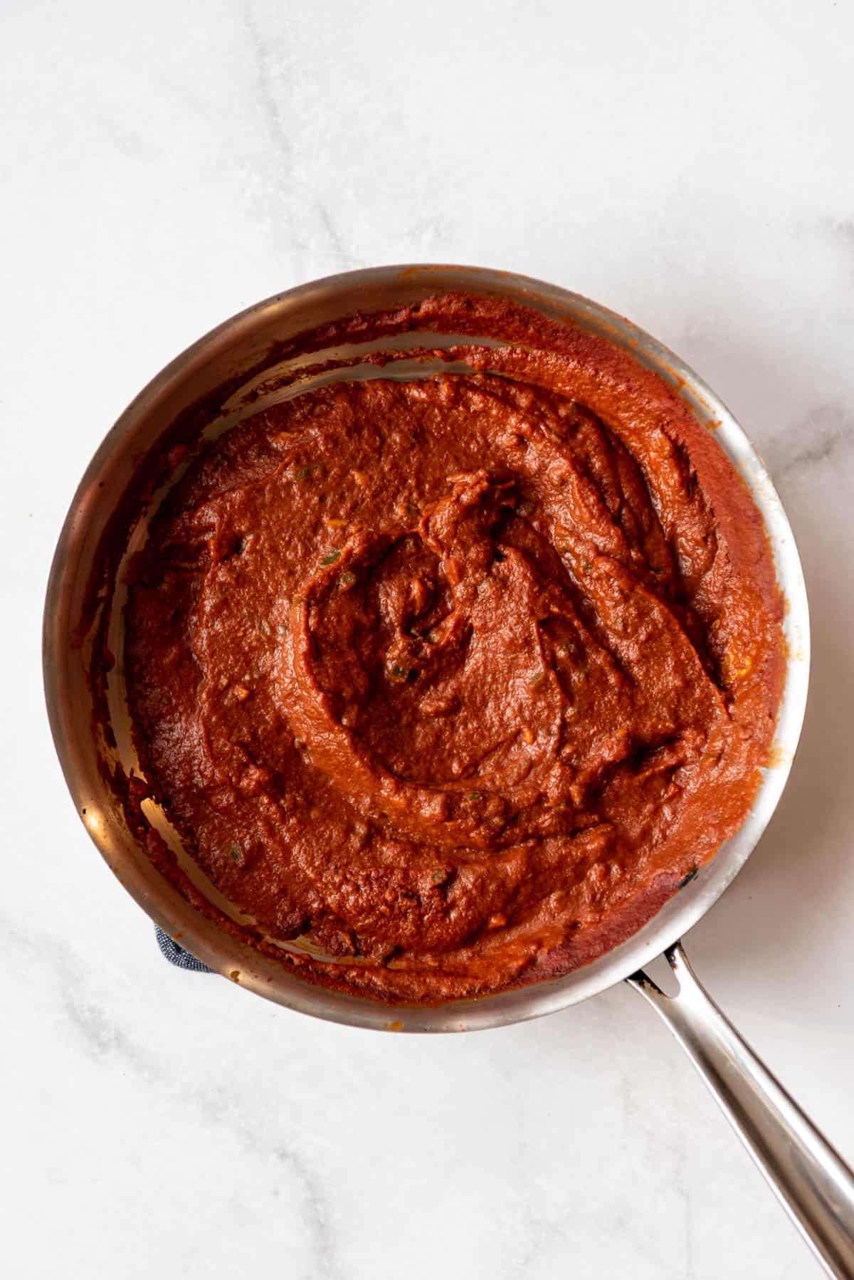 Cooked tomato masala sauce in a pan.