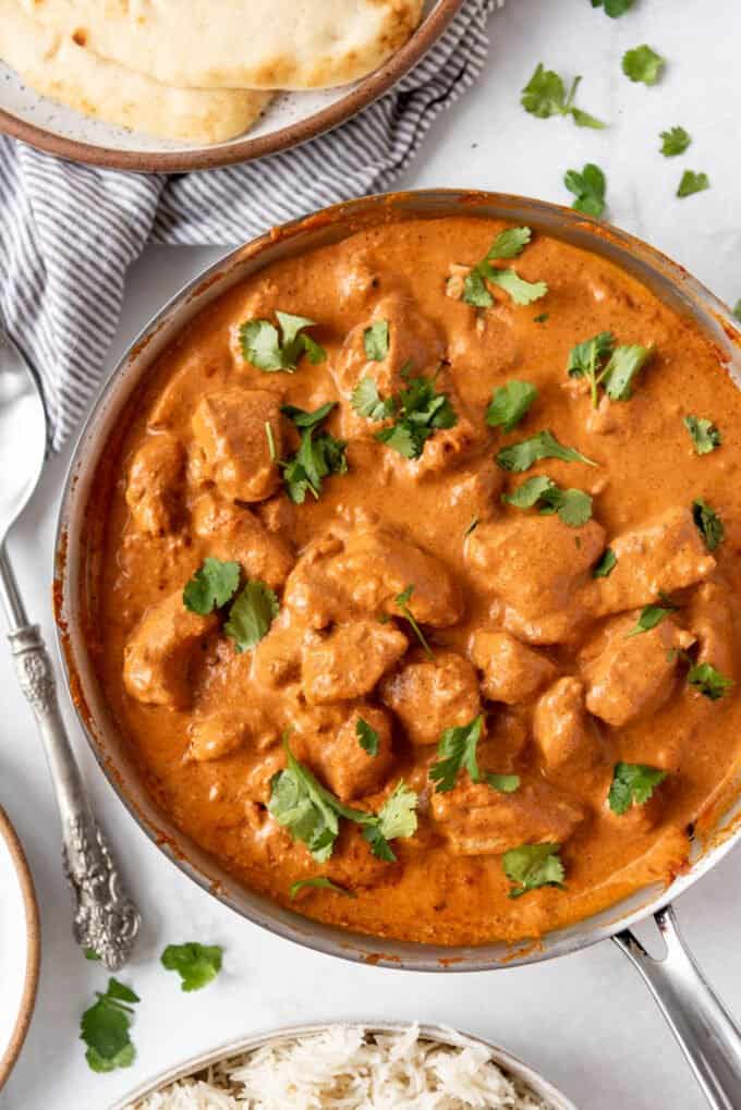 A large pan filled with homemade chicken tikka masala sprinkled with chopped cilantro.