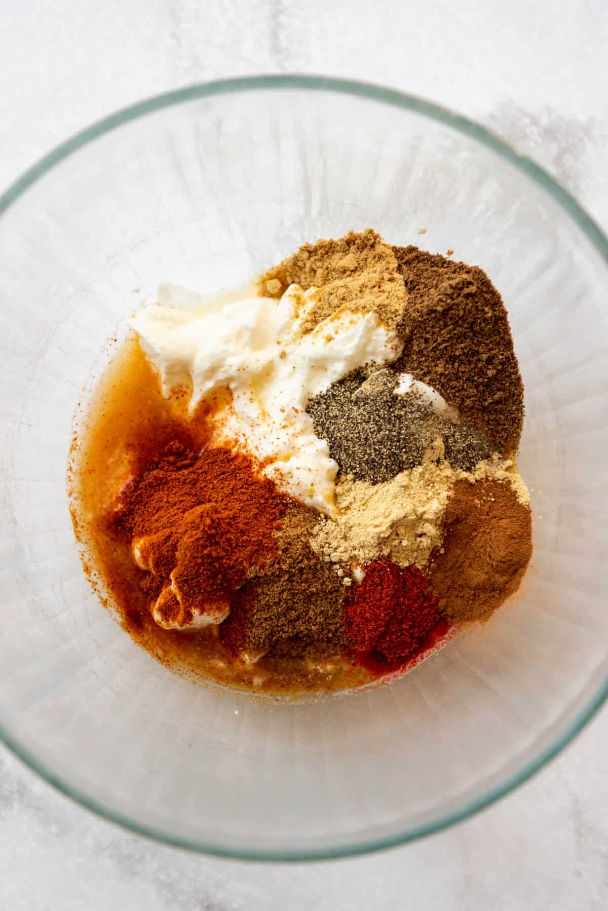 Adding spices to a bowl of plain yogurt.