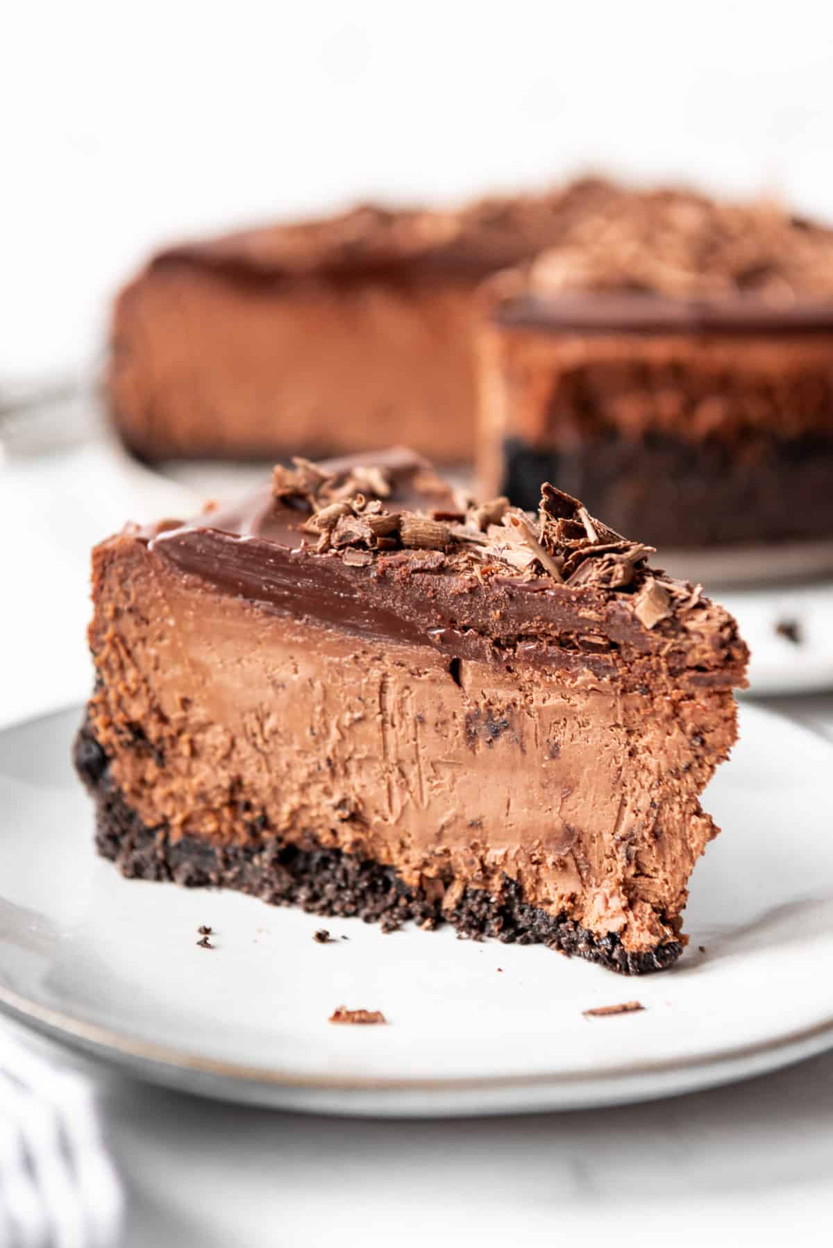 A slice of triple chocolate cheesecake on a plate. 