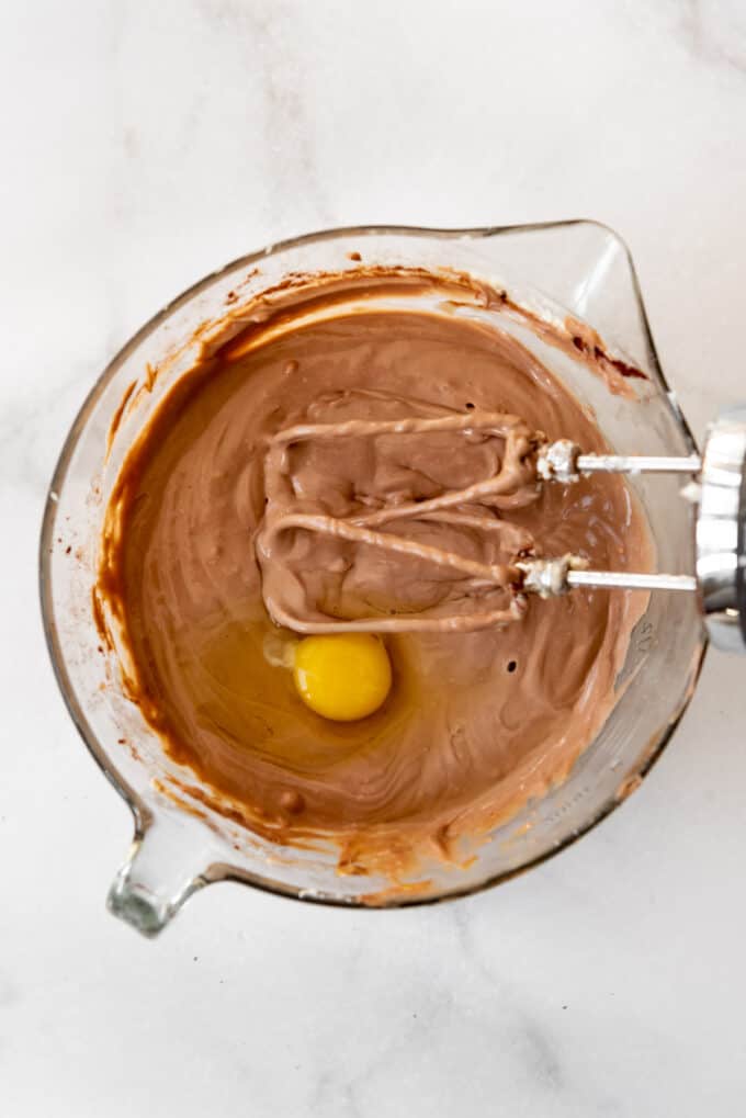 Chocolate cheesecake batter with an egg.