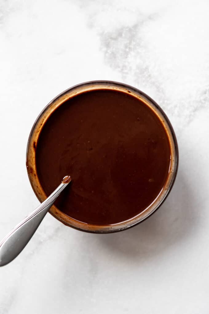 Chocolate ganache in a bowl with a spoon.