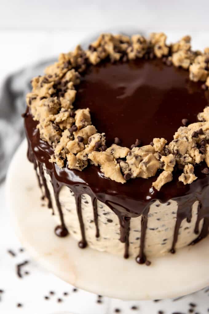 An overhead image of chocolate ganache topped with edible cookie dough on a homemade chocolate chip cake.