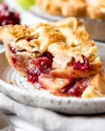 A slice of cranberry apple pie on a plate.