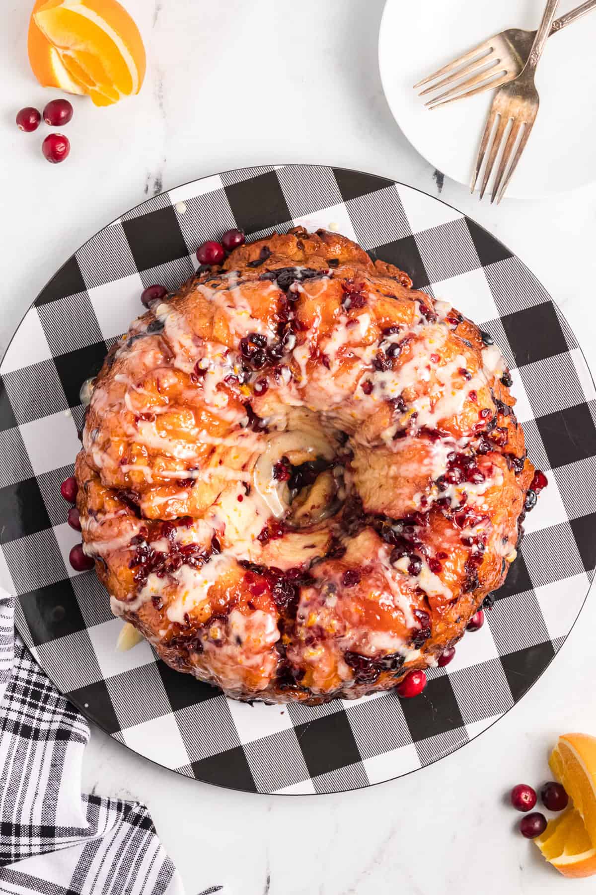 Homemade cranberry orange monkey bread on a black and white checkered plate.