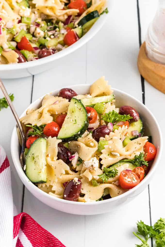 A bowl of picnic pasta salad made with Greek dressing.