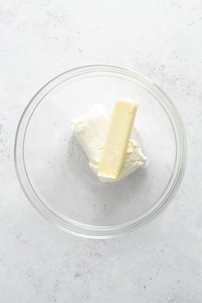 Softened butter and cream cheese in a glass bowl.