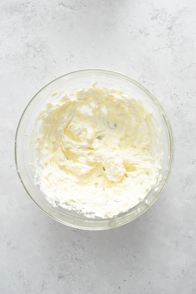 Creamy beaten cream cheese and butter in a glass bowl.