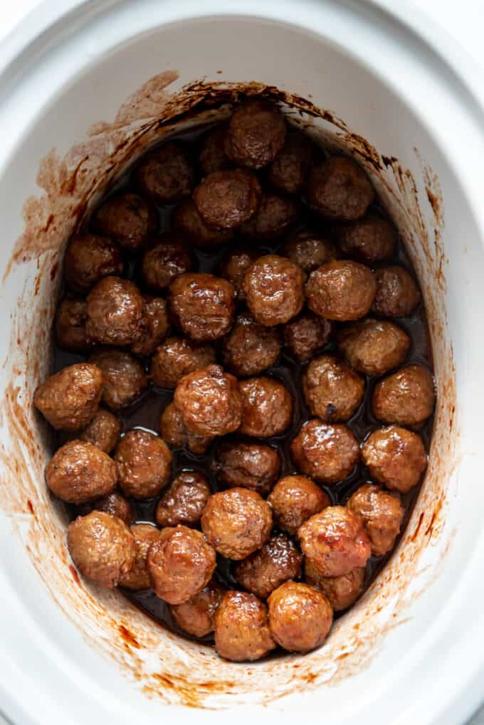 3-ingredient grape jelly meatballs in a white slow cooker.