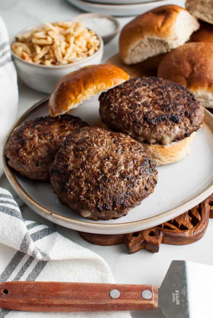 Cooked juicy lucy burgers on a plate.