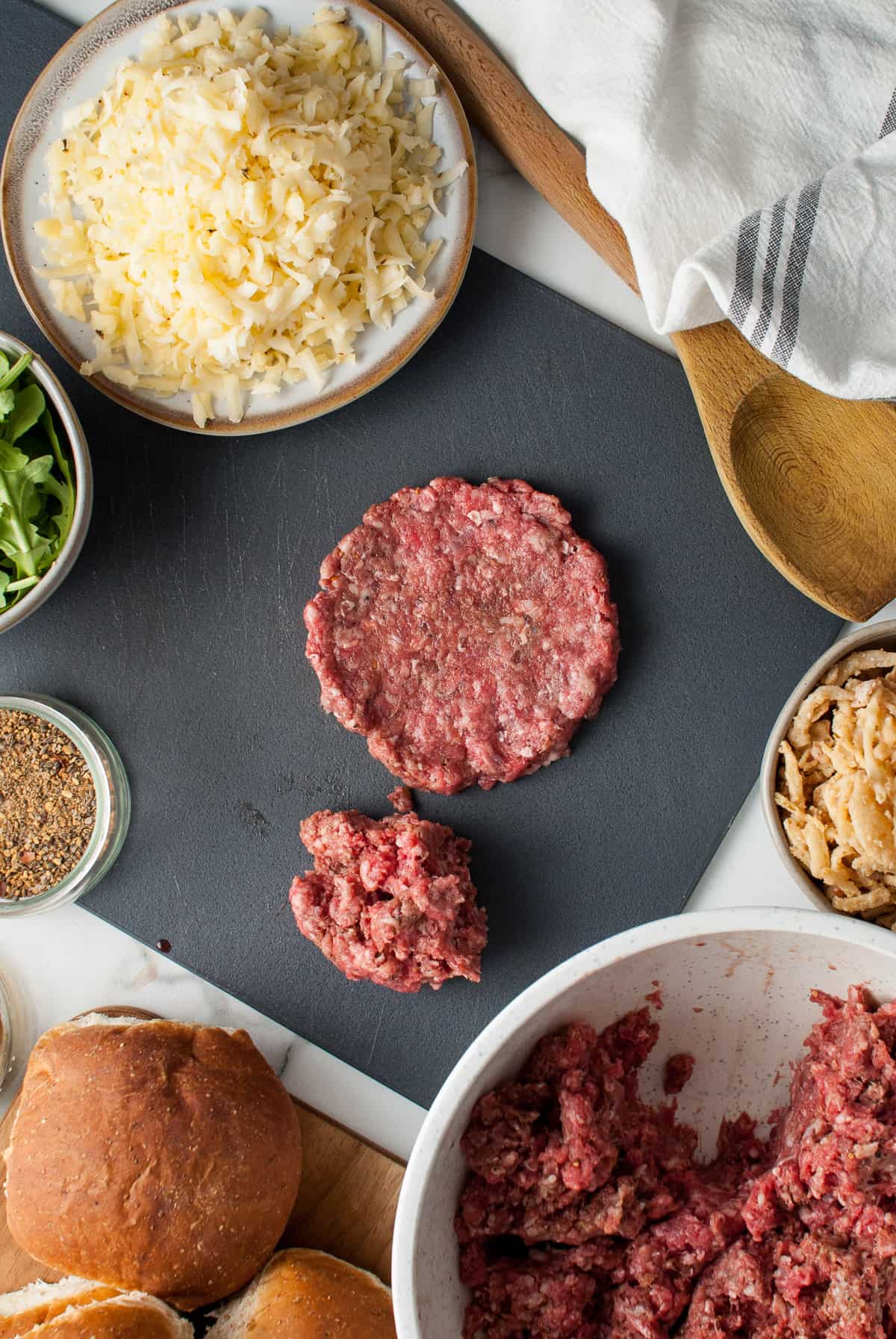 Flattening seasoned ground beef to make a hamburger patty.