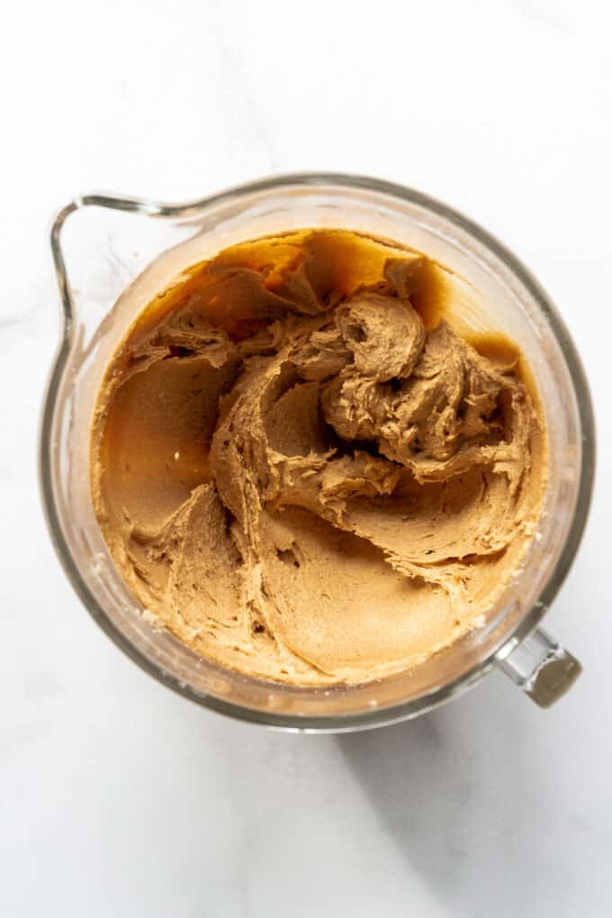 Creamed peanut butter, butter, granulated sugar, and brown sugar in a glass mixing bowl.