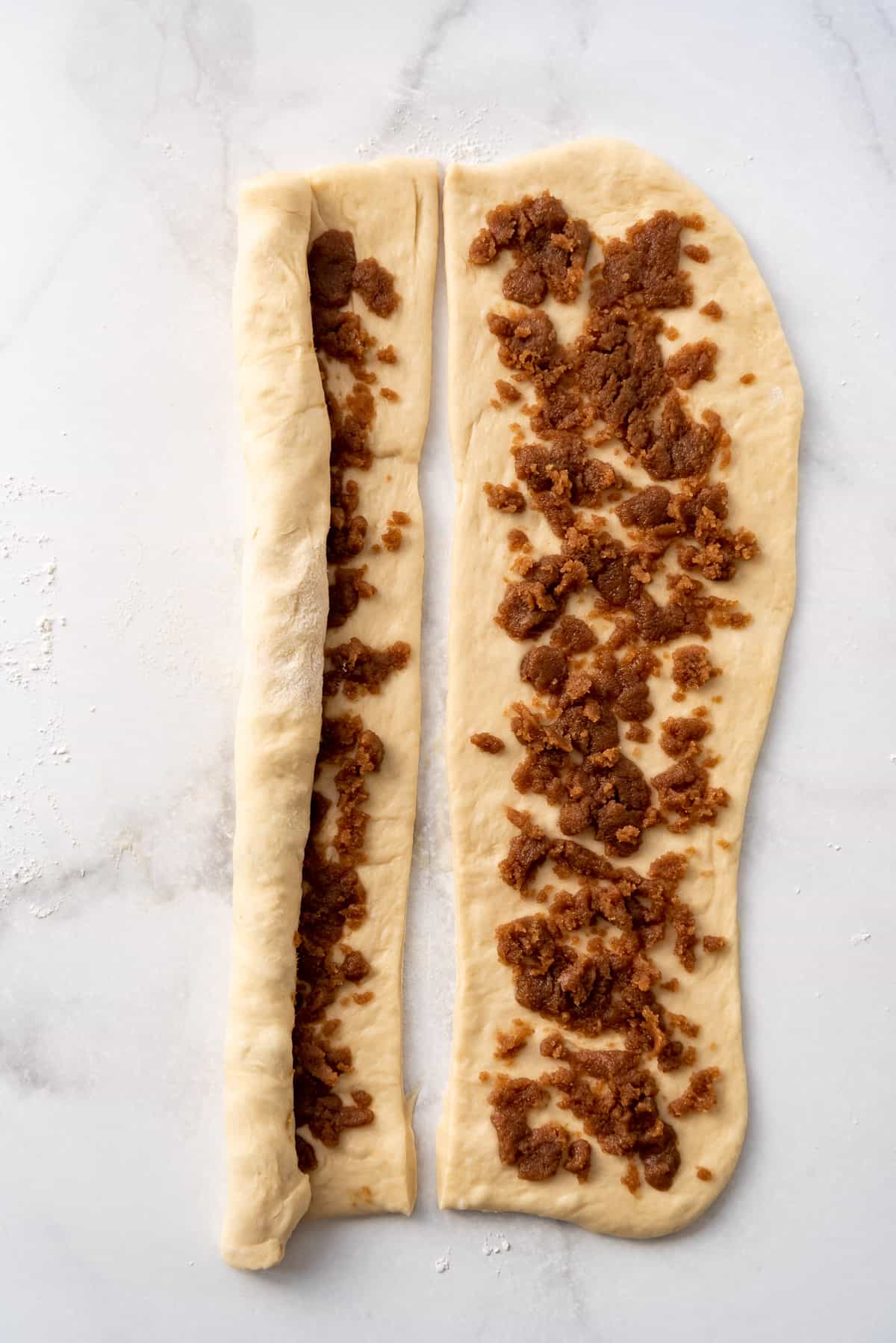 Rolling up sweet roll dough with cinnamon sugar filling.