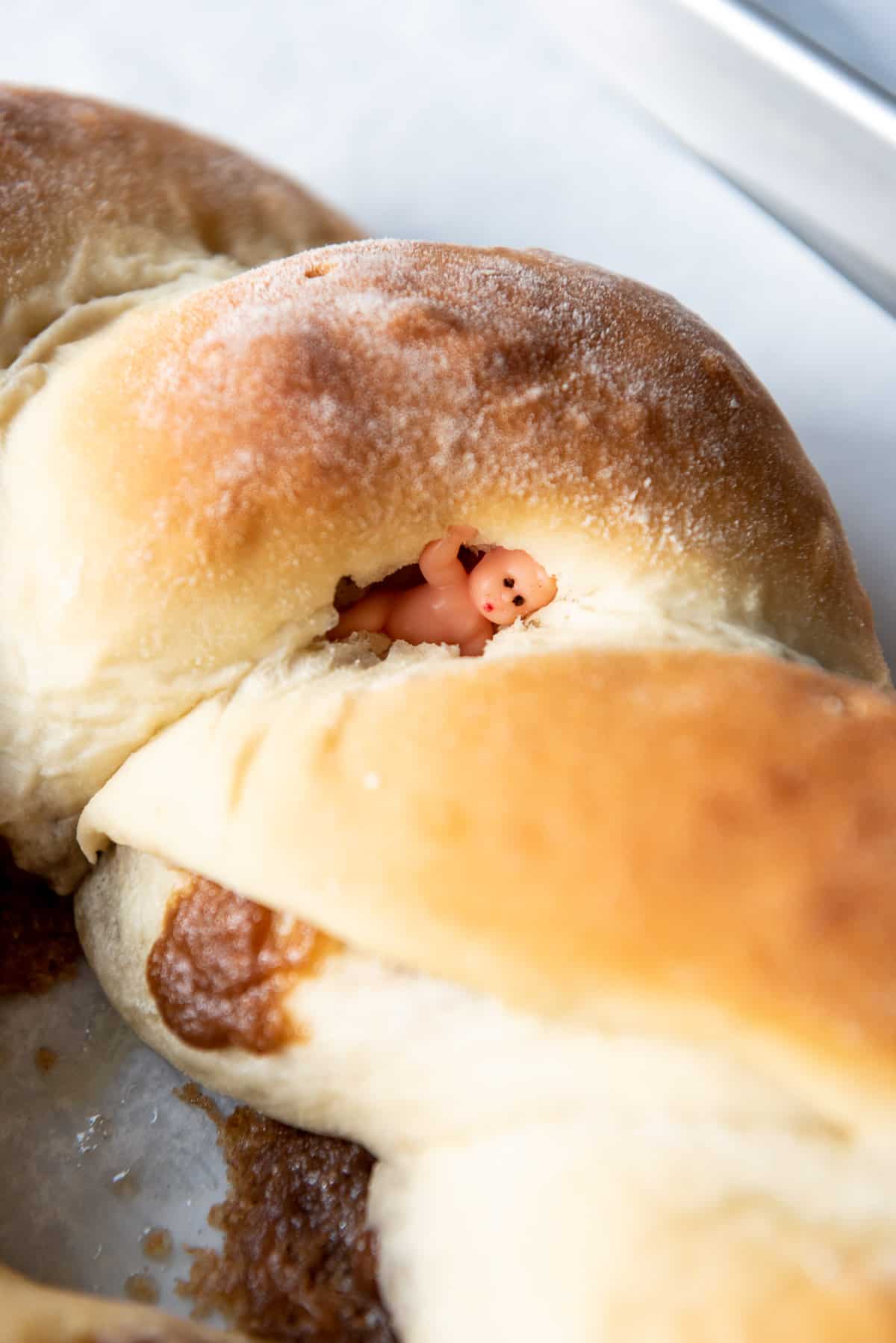 Hiding a miniature plastic toy baby in a baked king cake.