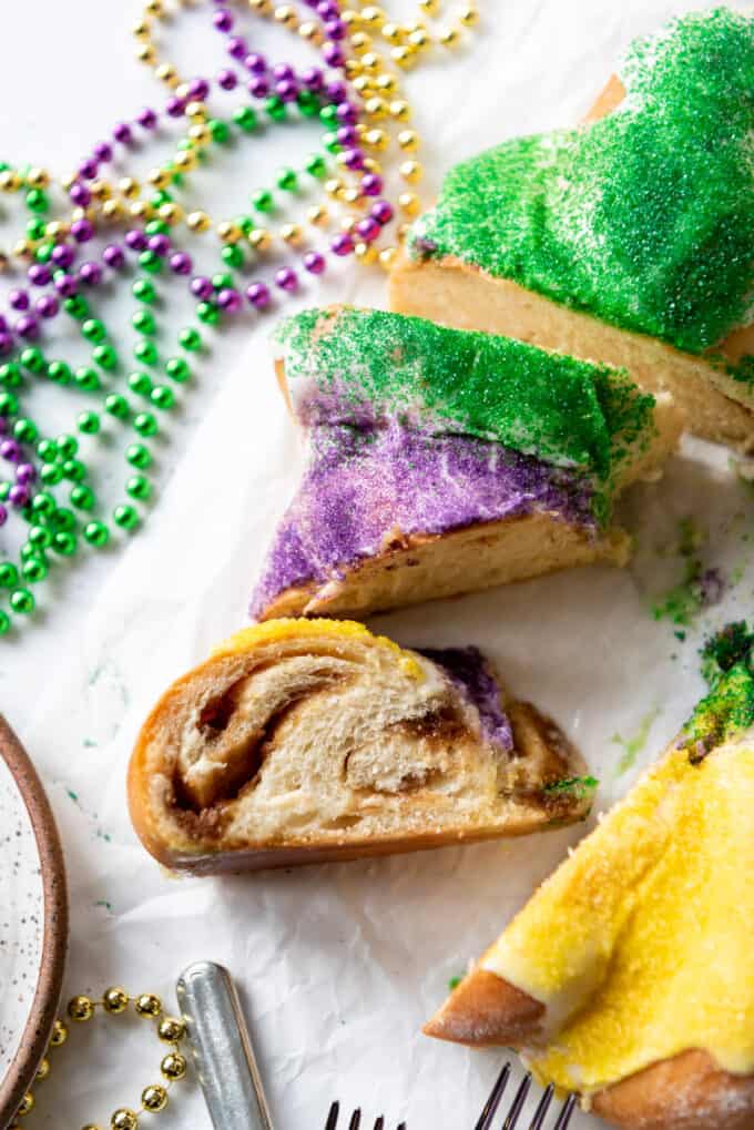 A sliced king cake with swirls of cinnamon filling.
