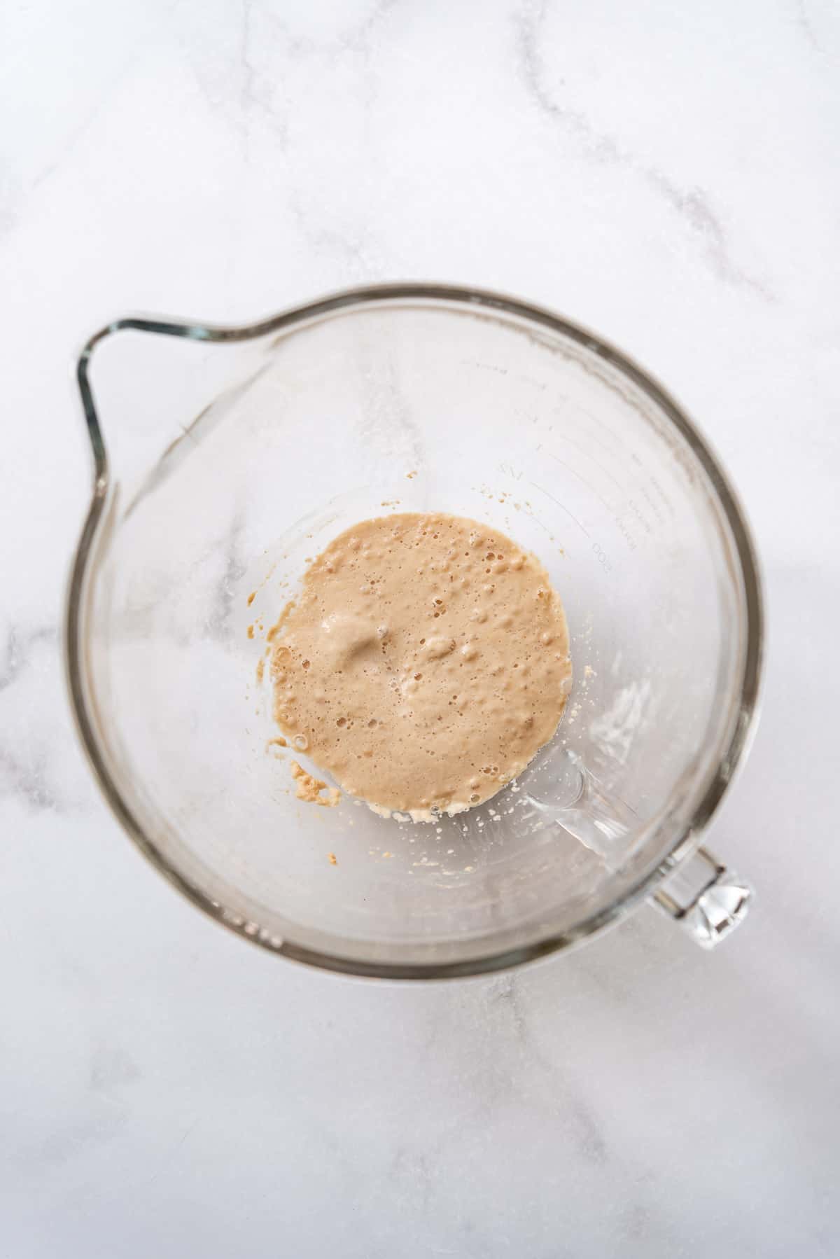 Foamy proofed active dry yeast in a glass bowl.