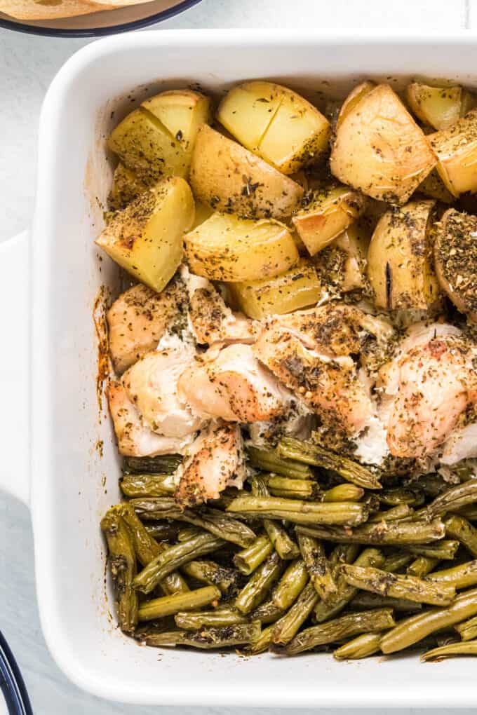 A close image of potatoes, green beans, and chicken cooked in one pan.