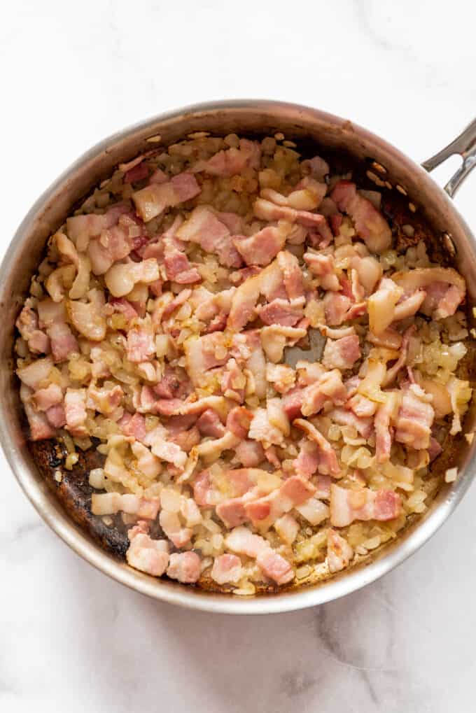 Cooking bacon and onions in a pan.