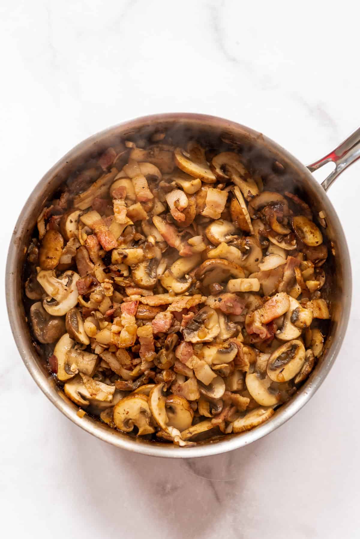 Sauteed mushrooms and onions in a pan.