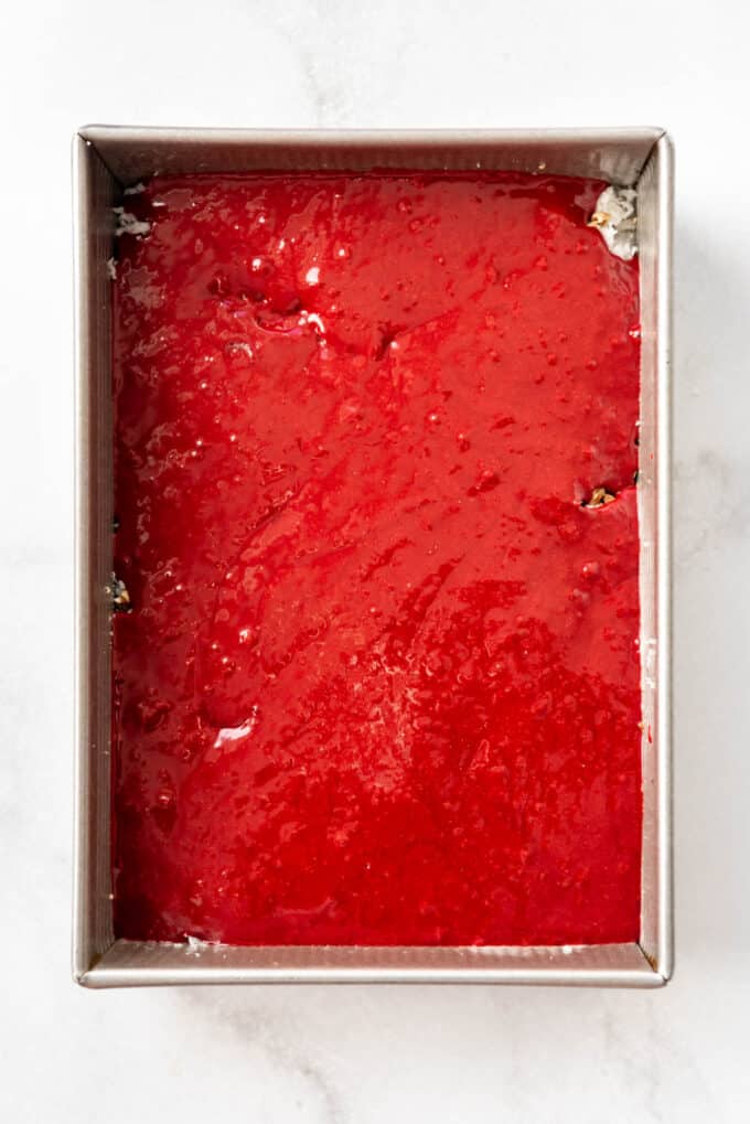 Red velvet cake batter in a rectangular baking dish.