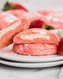 A plate with strawberry cake mix cookies stuffed with cheesecake filling on it.