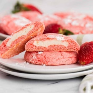 A plate with strawberry cake mix cookies stuffed with cheesecake filling on it.