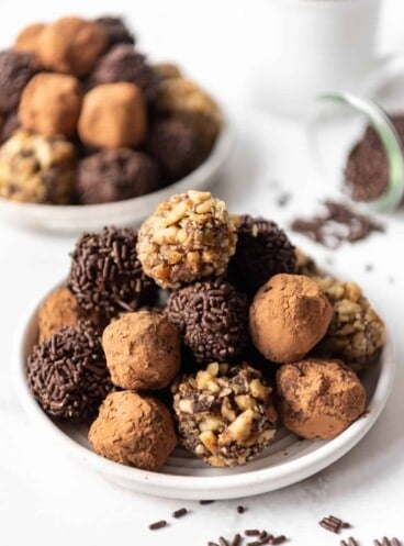 Chocolate truffles in various coatings piled on a plate.
