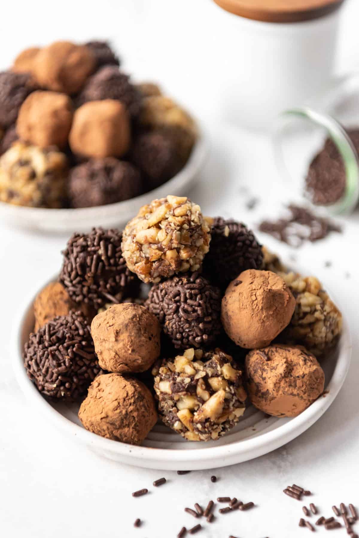 Chocolate truffles in various coatings piled on a plate.