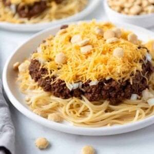 A plate of Cincinnati chili on top of spaghetti noodles.