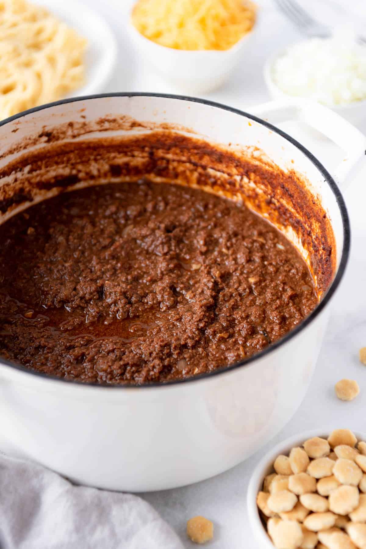 Thick Cincinnati Chili in a white Dutch oven.