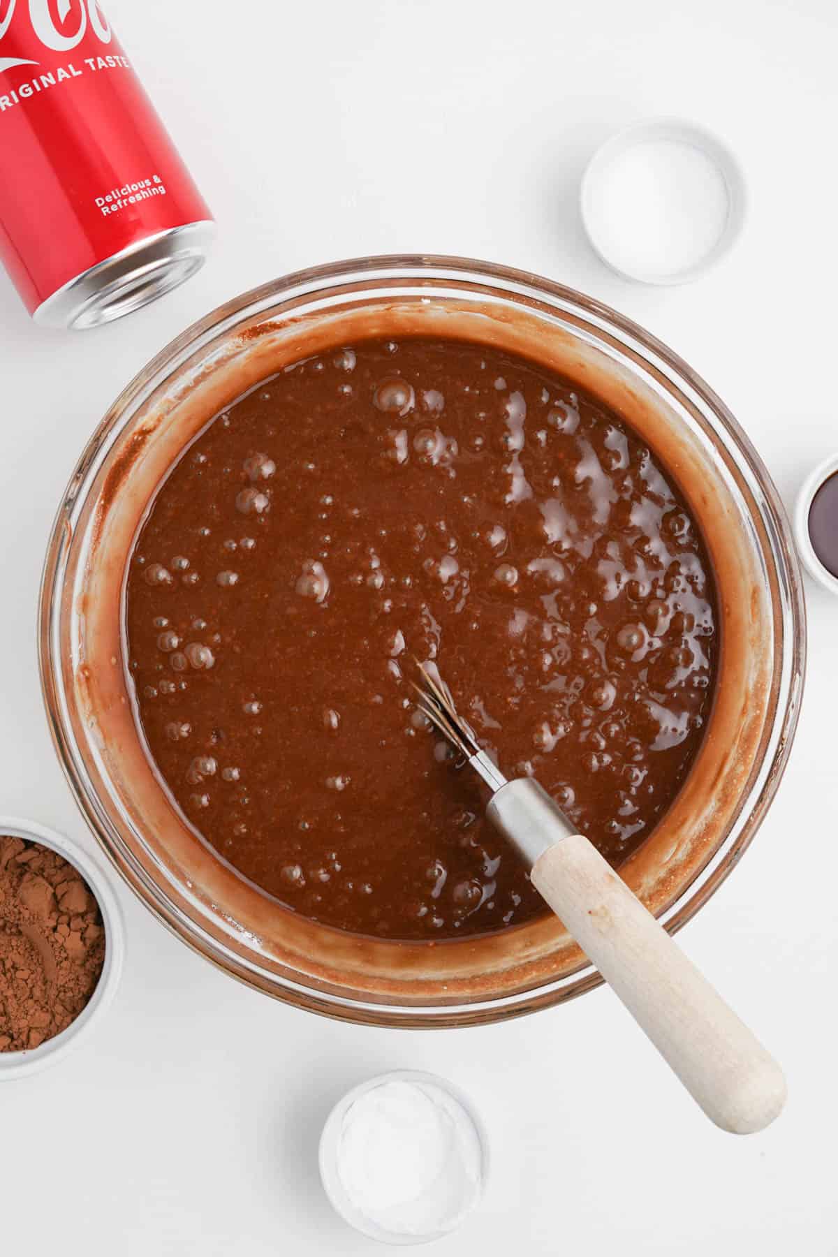 Chocolate coca cola cake batter in a glass bowl.