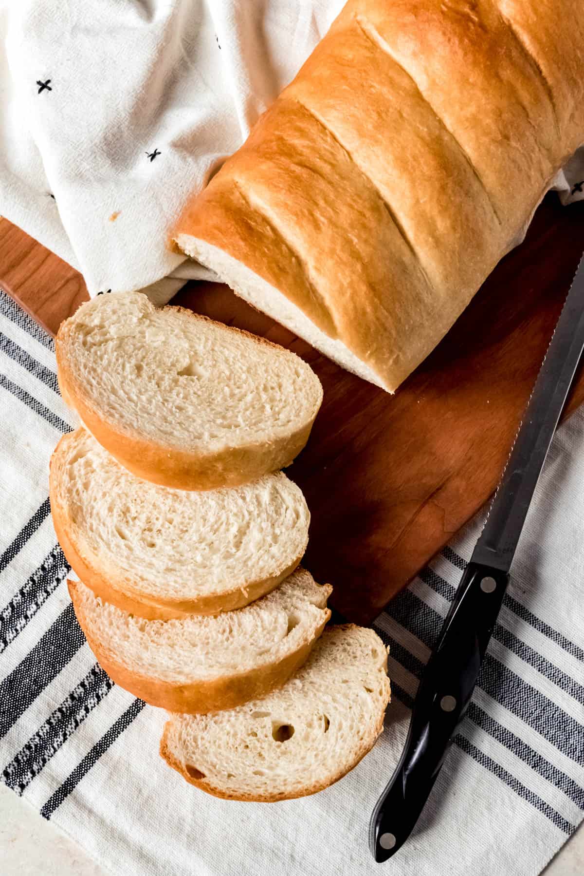 An overhead image of slices of French bread next to the remaining loaf.