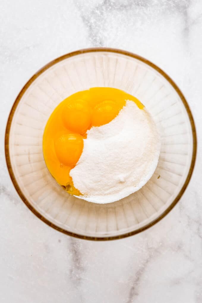 Sugar and egg yolks in a glass bowl.