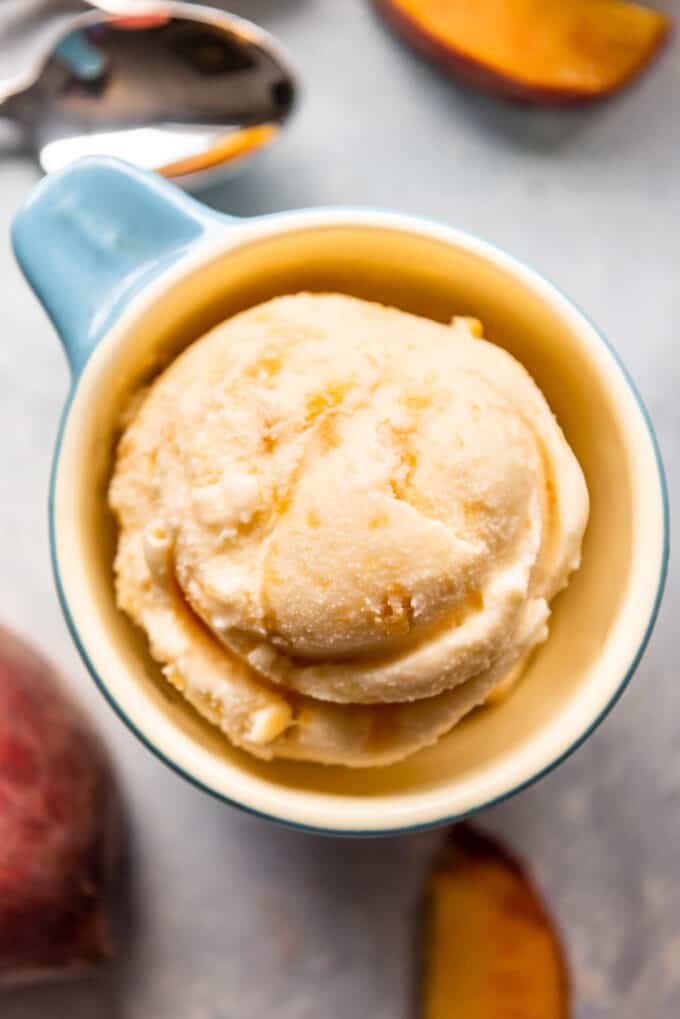 An overhead image of a cup full of homemade peach ice cream.