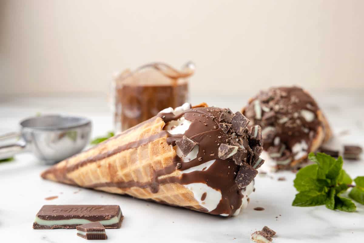 An ice cream cone lying on its side topped with Andes mint magic shell topping.