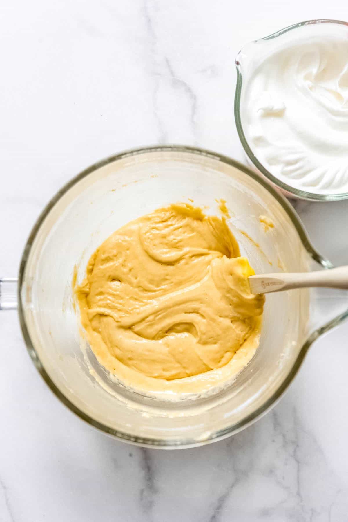 Stirring cake batter with a spatula.