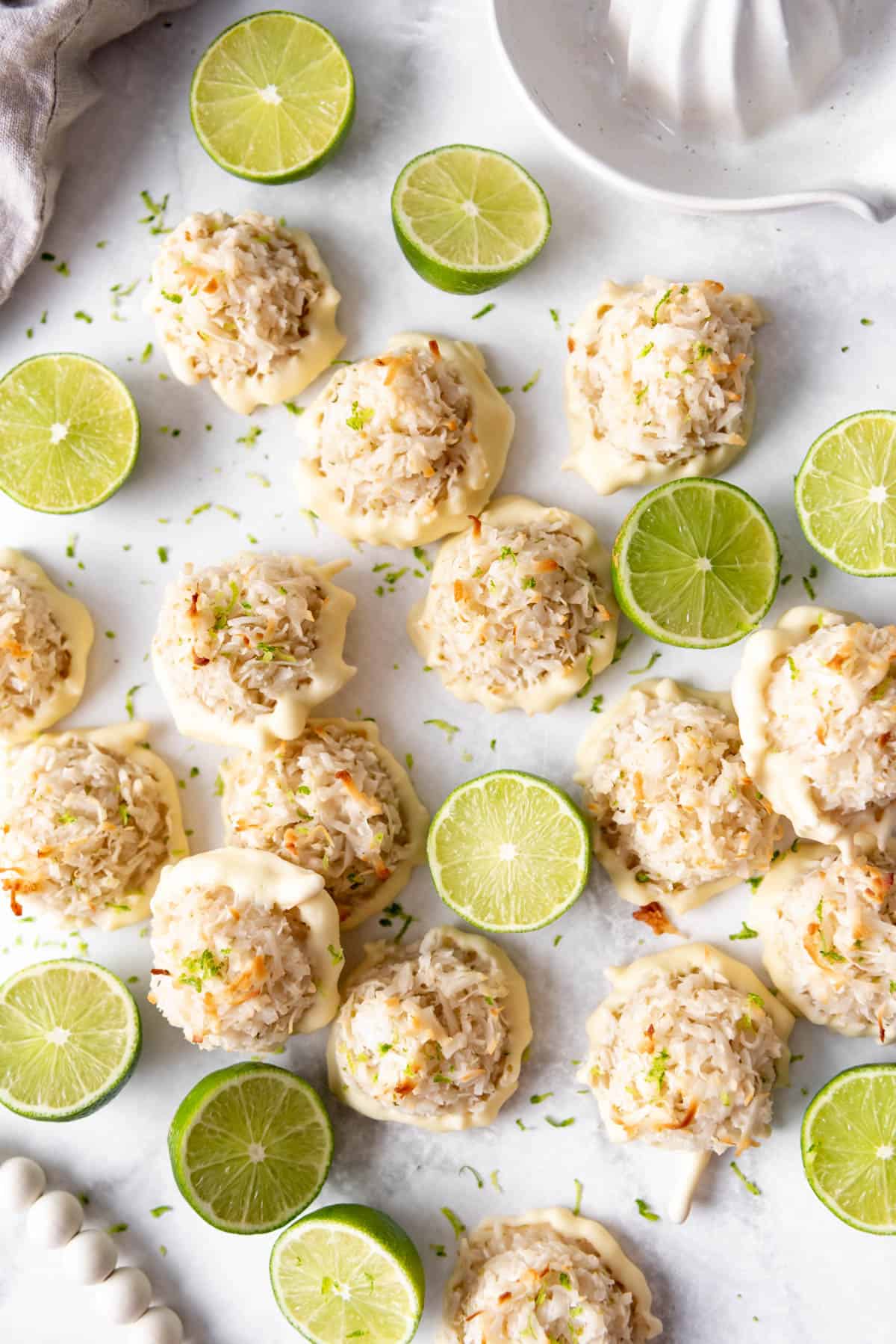 An overhead image of coconut lime macaroons with toasted coconut and fresh limes.