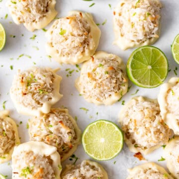 An overhead image of coconut lime macaroons with toasted coconut and fresh limes.
