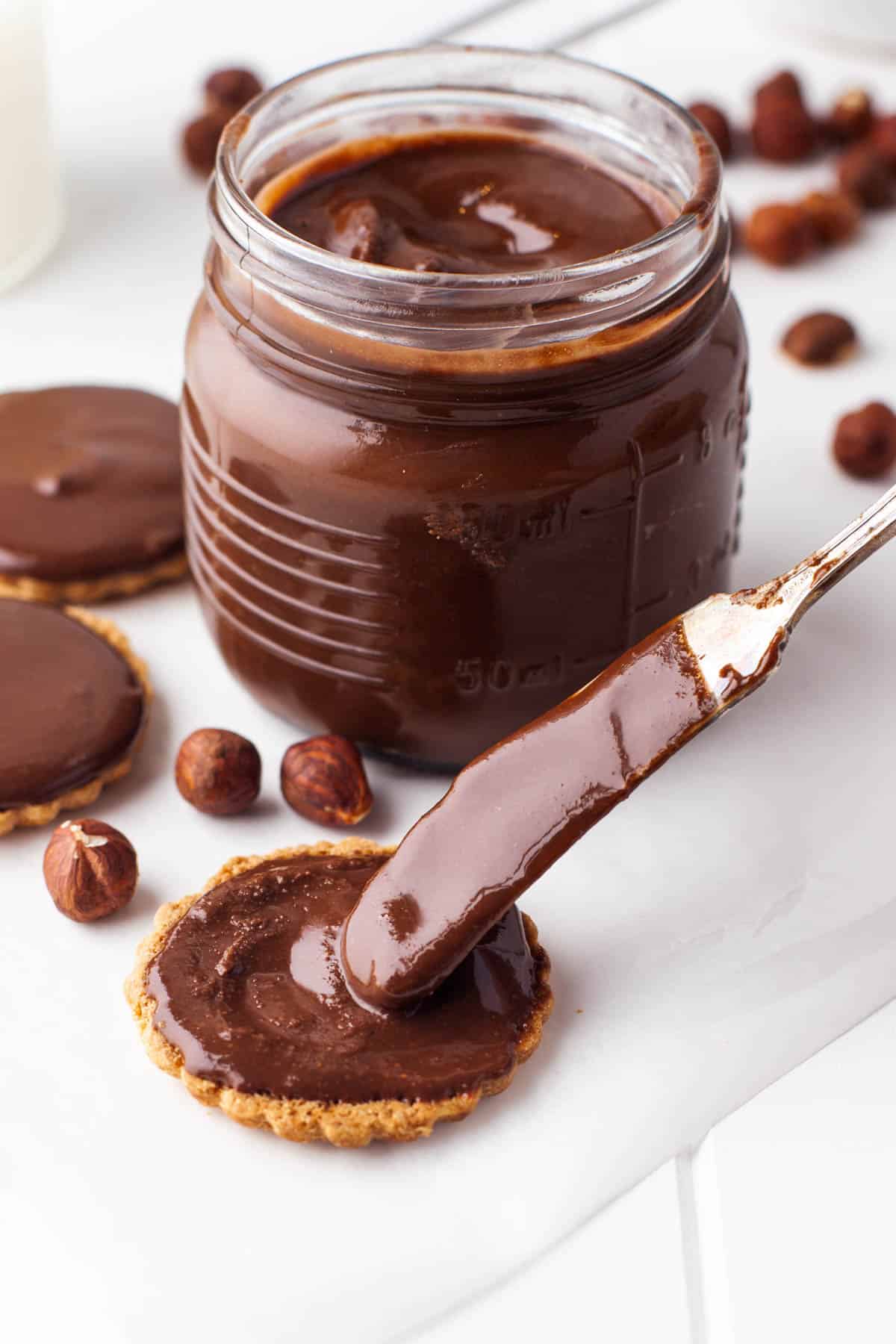 A knife spreading homemade Nutella on cookies.