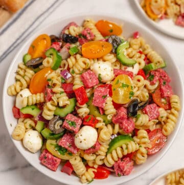 A large white serving bowl of Italian pasta salad.