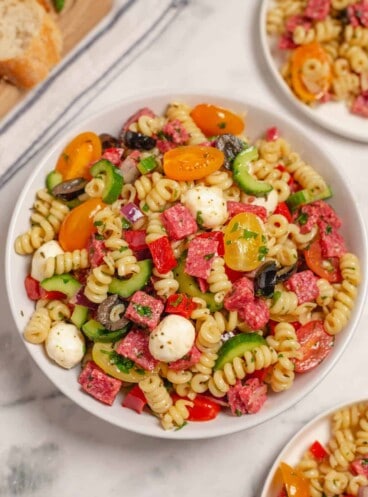 A large white serving bowl of Italian pasta salad.